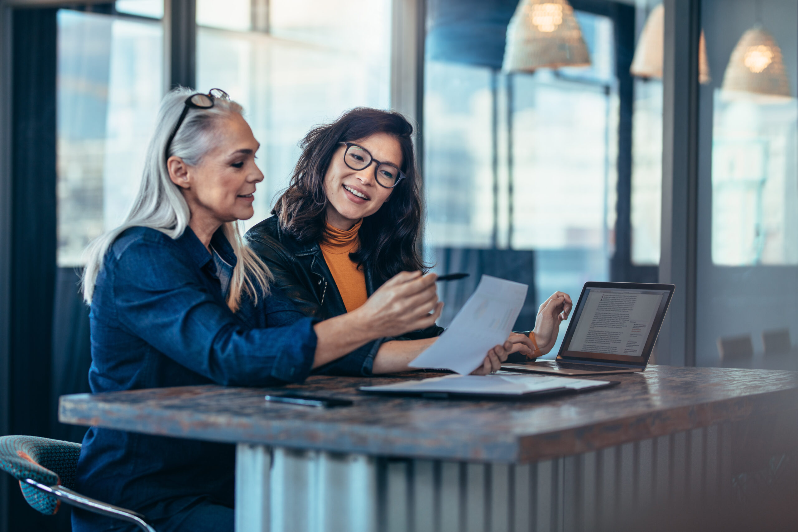 Two women analyzing documents