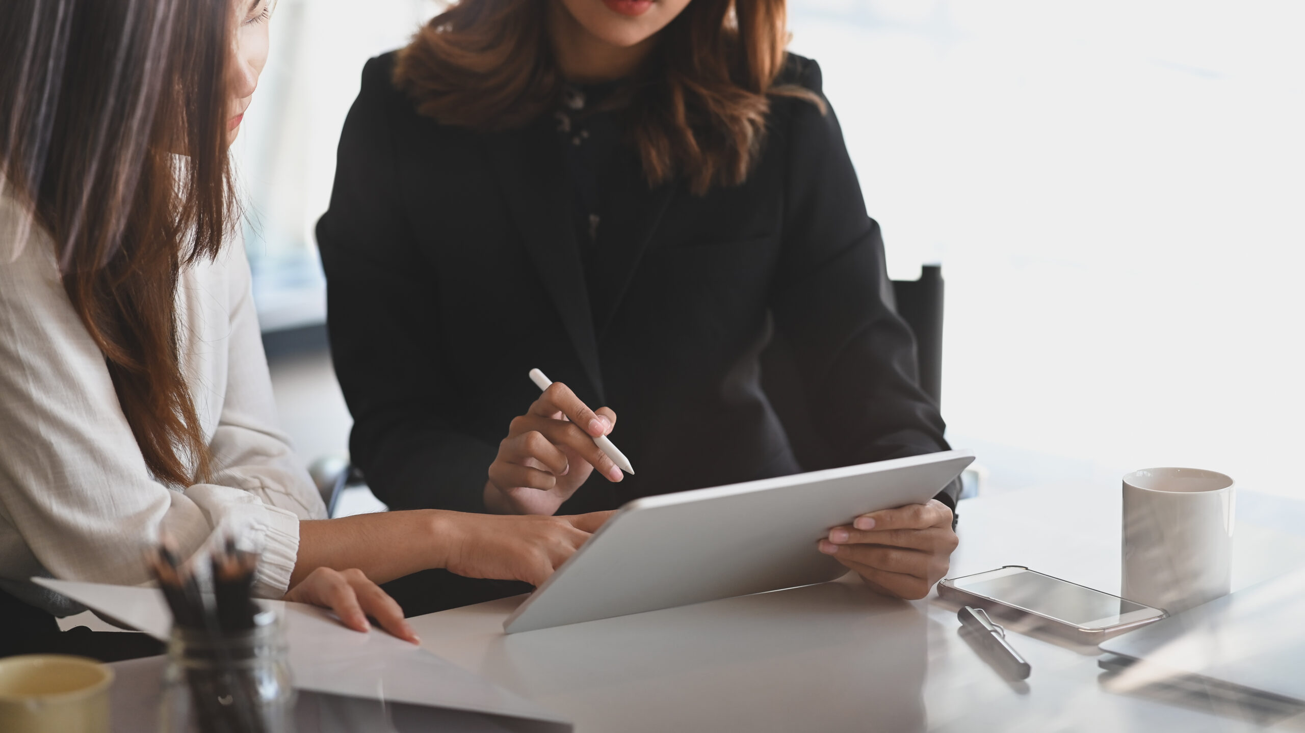 Cropped shot of woman while consulting to young businesswoman next to her.